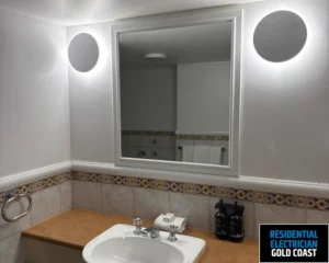 A bathroom with a well-lit mirror and sink area.